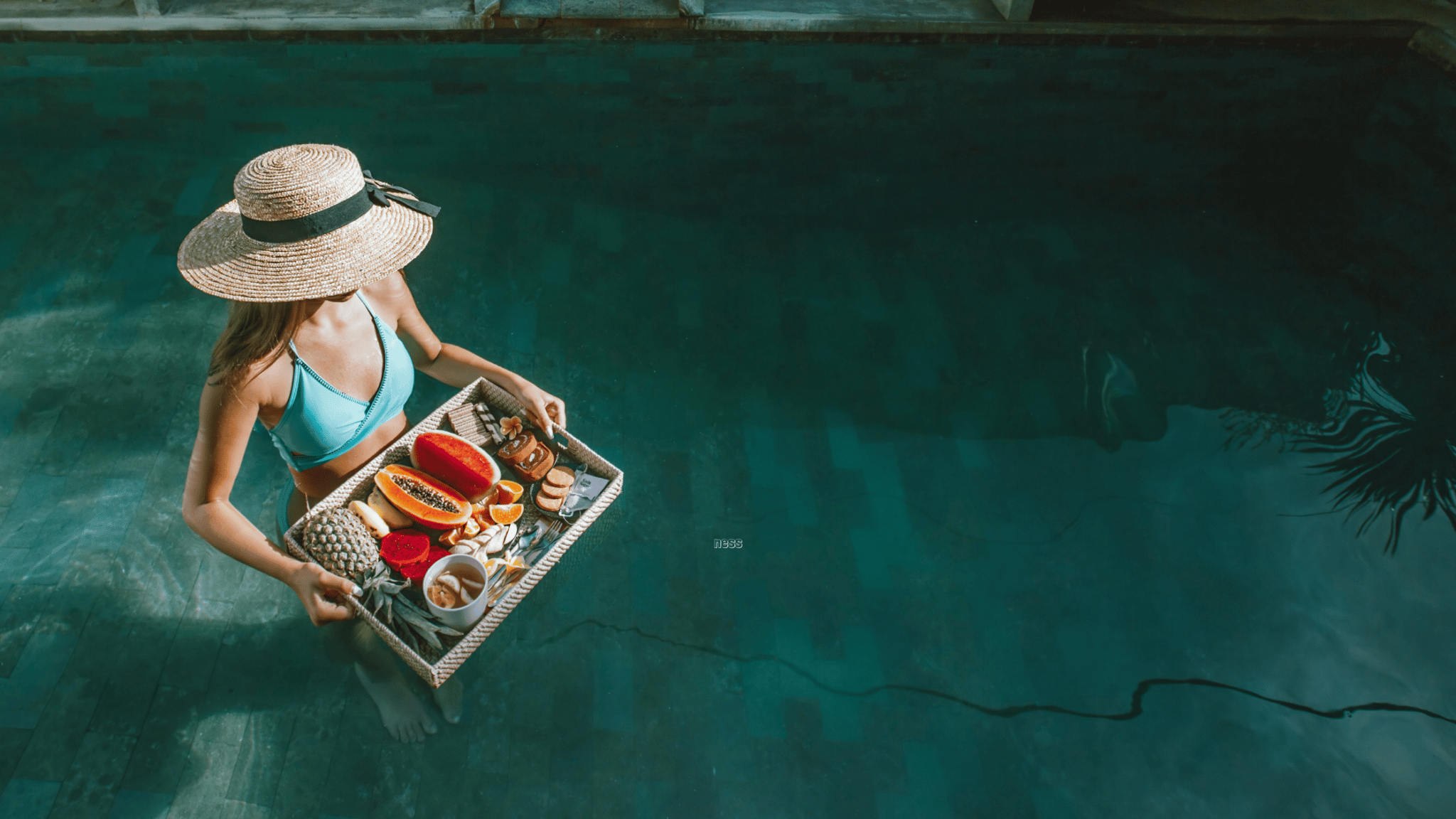 woman in water holding tray of fruit