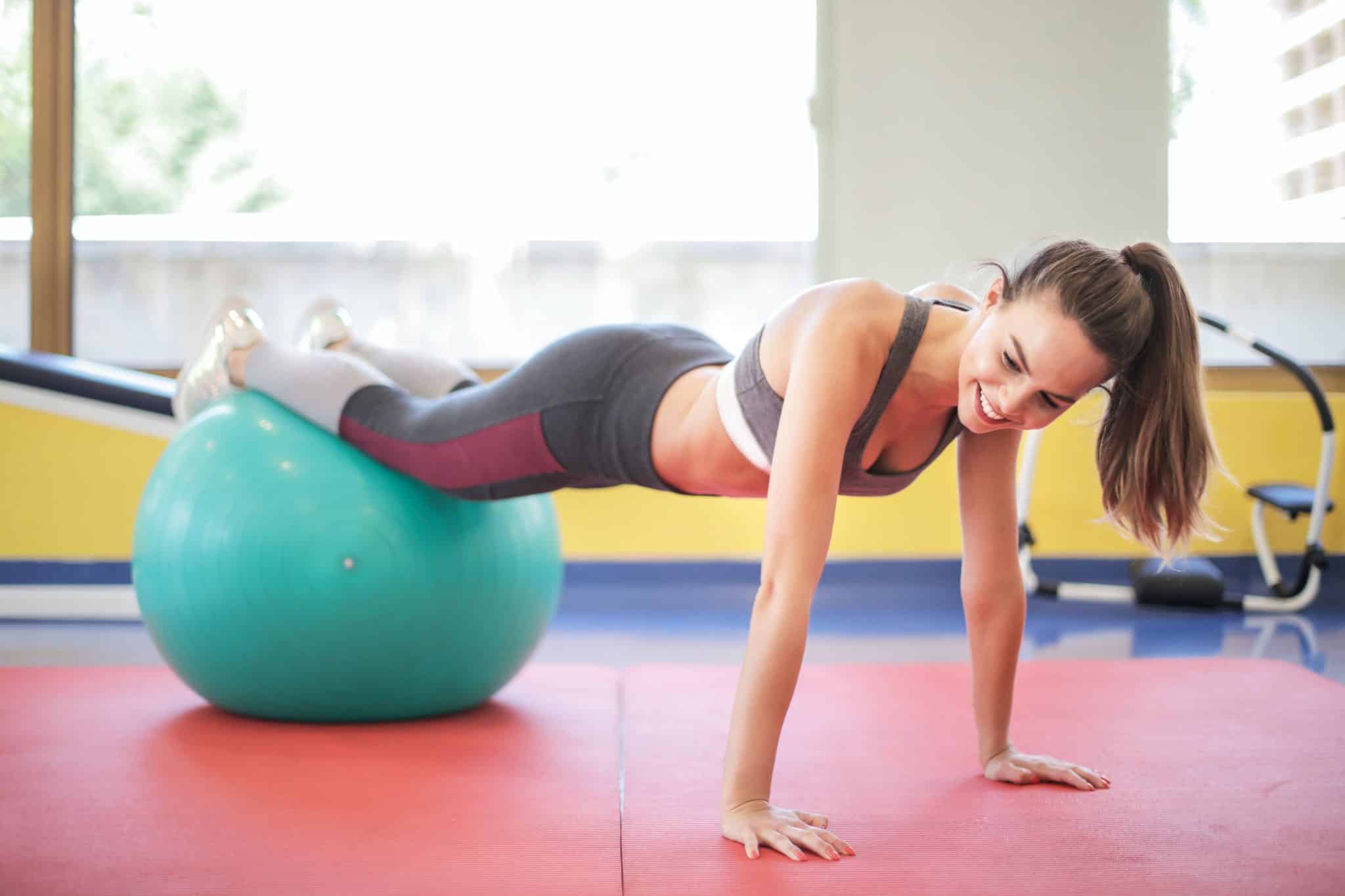 woman balancing on stability ball in plank position