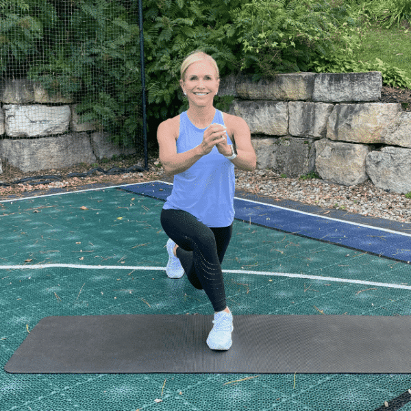 Chris Freytag holding a cross-behind lunge outside on a sports court.