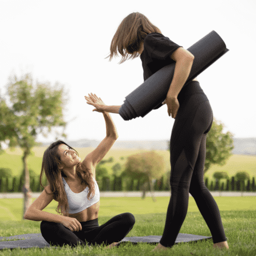 two woman high fiving after yoga
