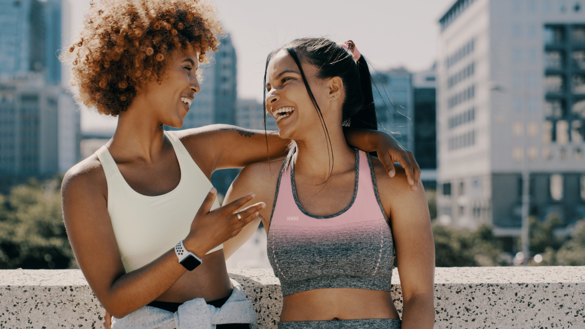 2 woman in fitness clothes laughing