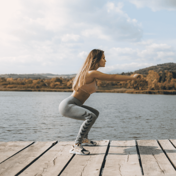 woman doing squat on a doc