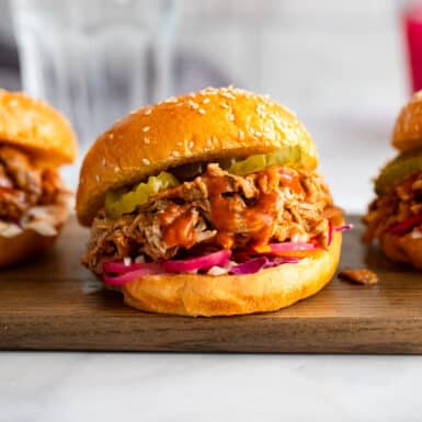 healthy pulled pork sandwiches on wooden serving board