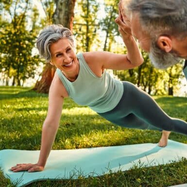 woman doing best core exercises for seniors on yoga mat outside plank