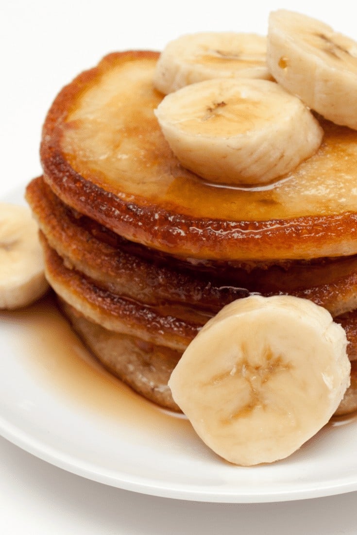 Banana pancakes in a stack with banana slices