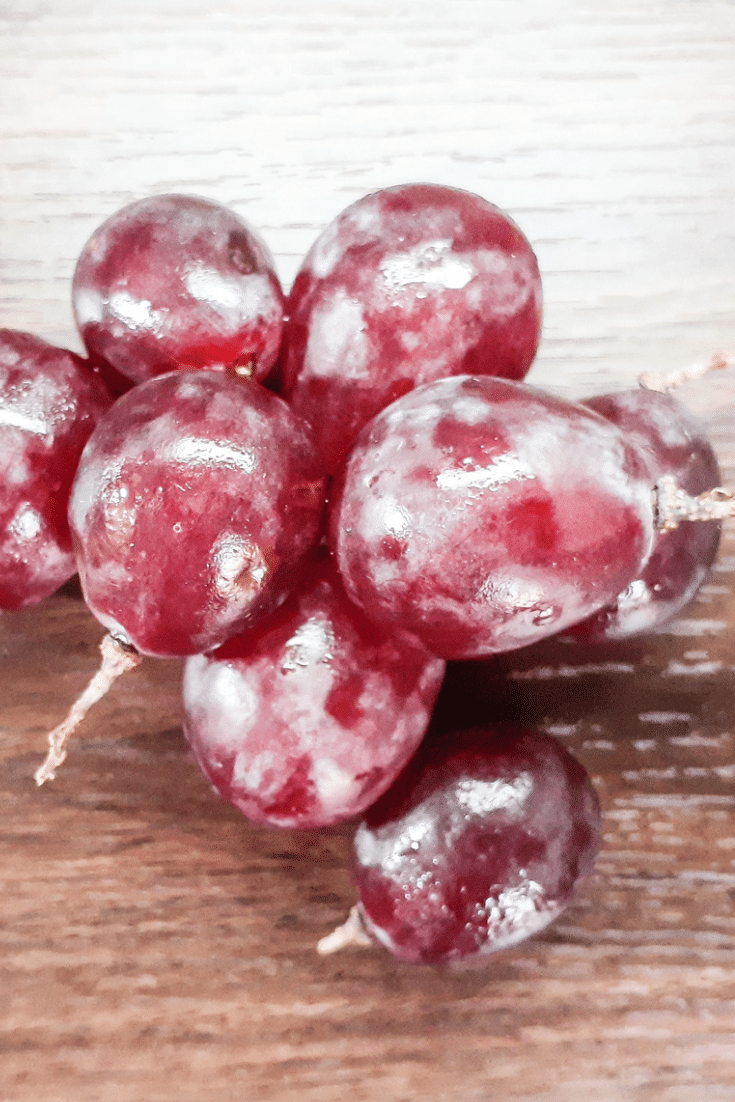 Frozen red grapes on wood