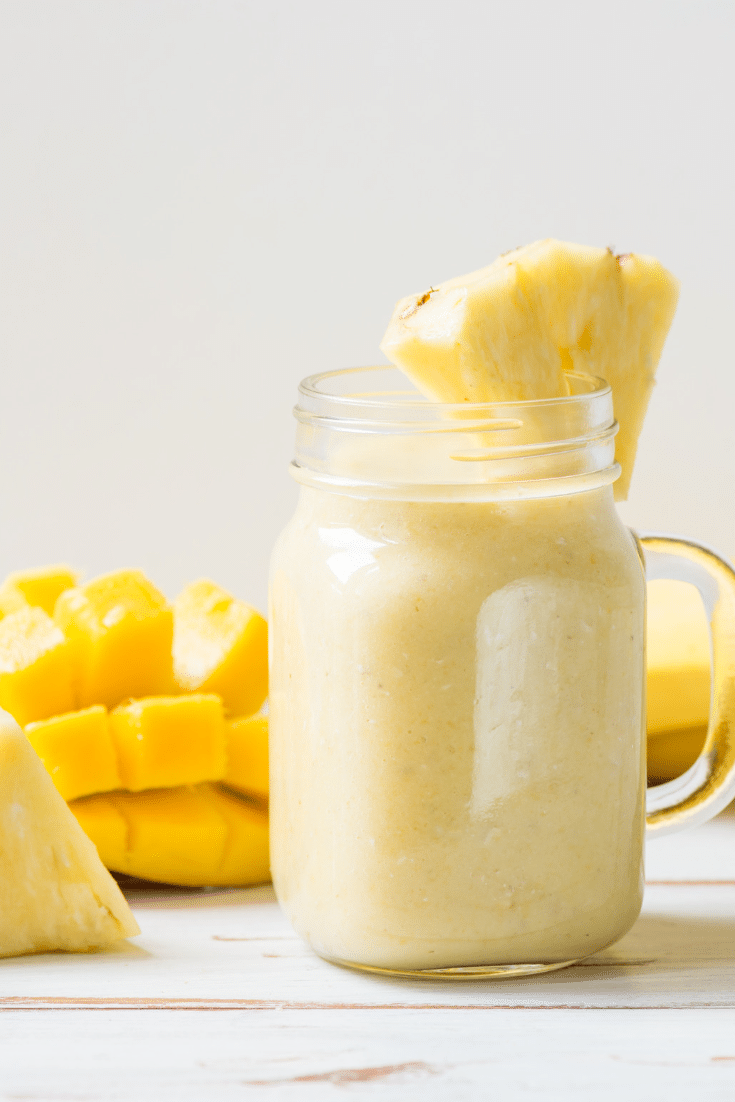 A tropical smoothie with pineapple and mango in a mason jar