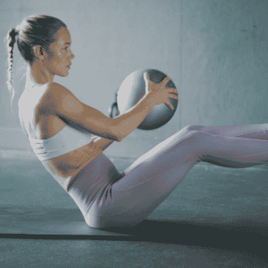 woman in purple leggins with medicine ball working out
