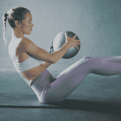 woman in purple leggins with medicine ball working out