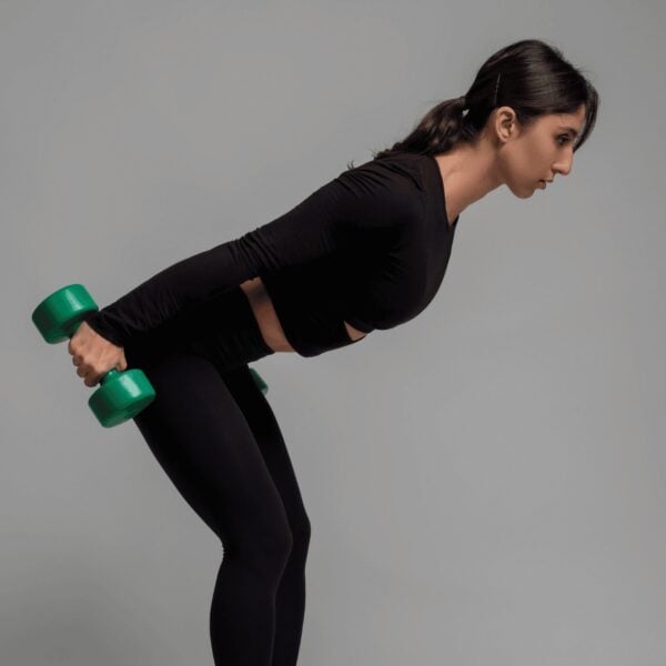 Young woman in black showing dumbbell tricep kickback form