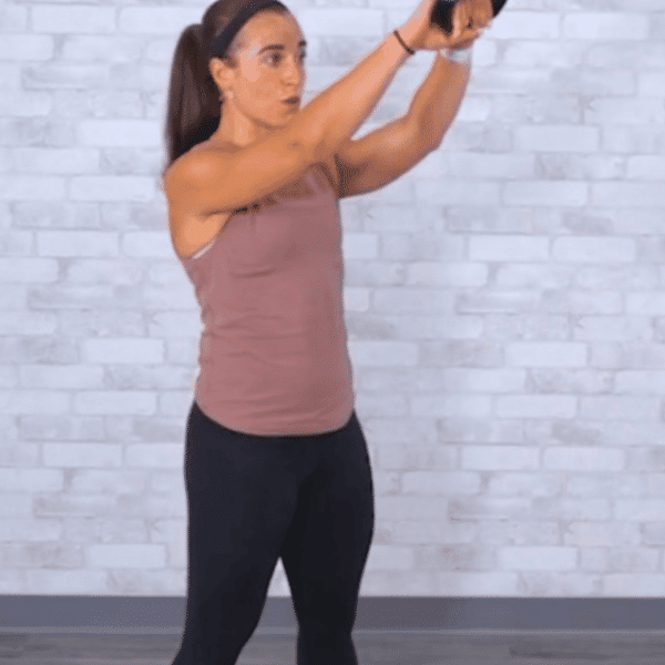 Get Healthy U TV Trainer Sam performing a kettlebell swing with a red kettlebell.