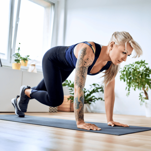 woman in workout clothing on black yoga mat