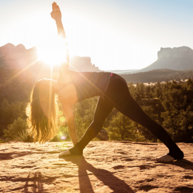 woman doing yoga in canyon as sun rises