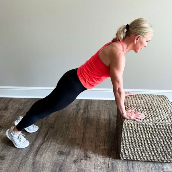 woman showing how to get better at push ups with modification on box