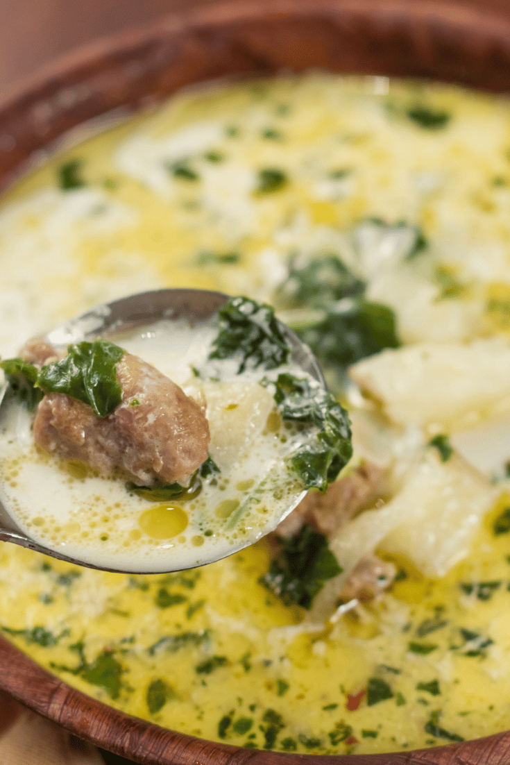 Close up of spoon serving sausage and kale soup