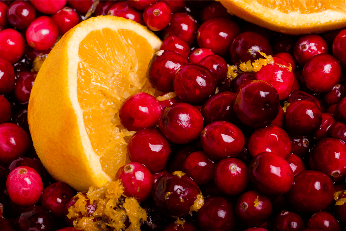 Close up of fresh cranberries and a half orange