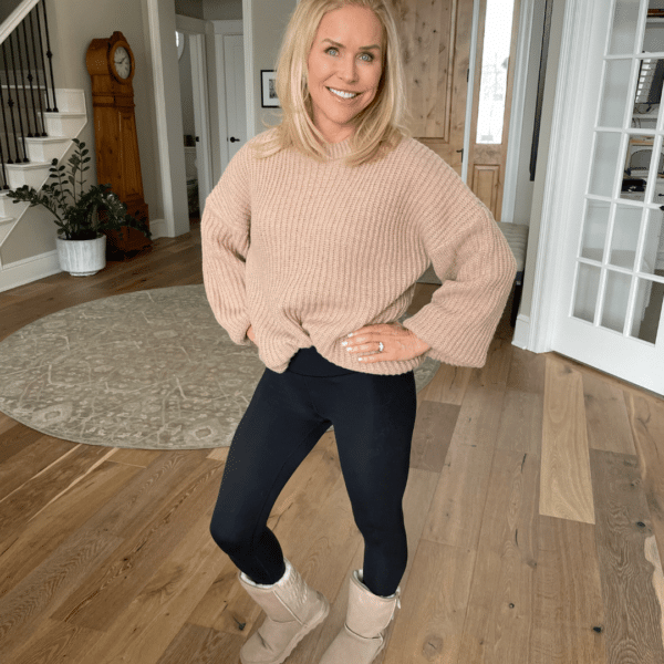 Chris Freytag wearing an oversized chestnut sweater, hands on hips, with a matching color pair of UGG brand boots.