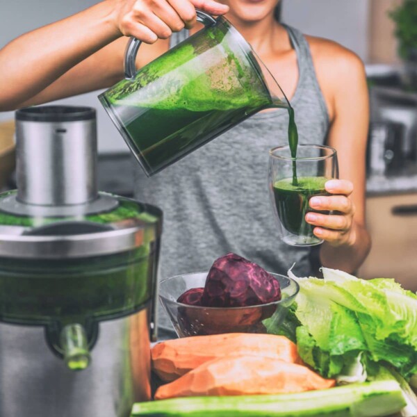 woman pouring fresh green juice