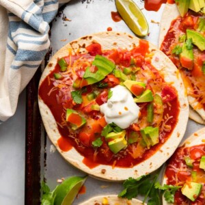 healthy Mexican pizza topped with avocado on a sheet pan.