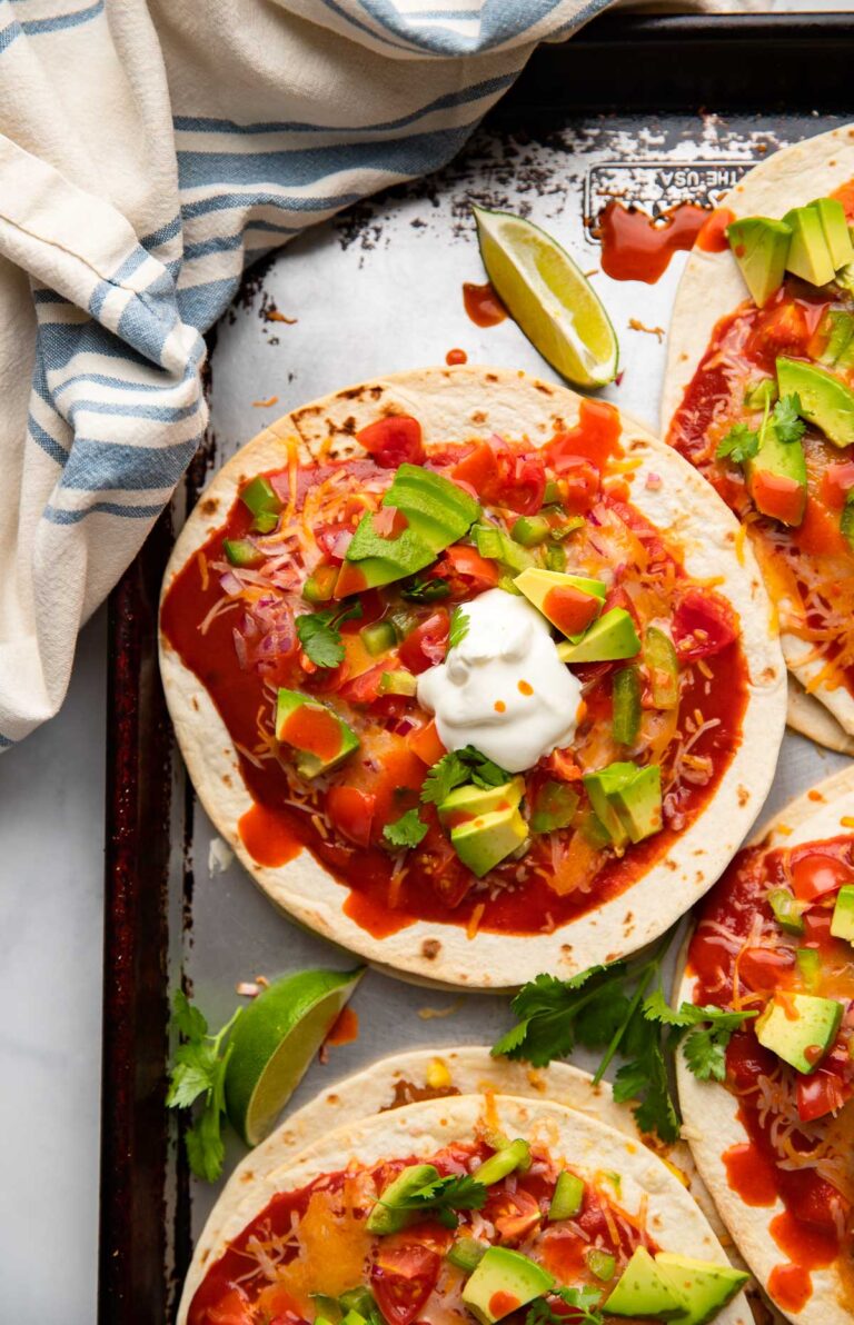 healthy Mexican pizza topped with avocado on a sheet pan.