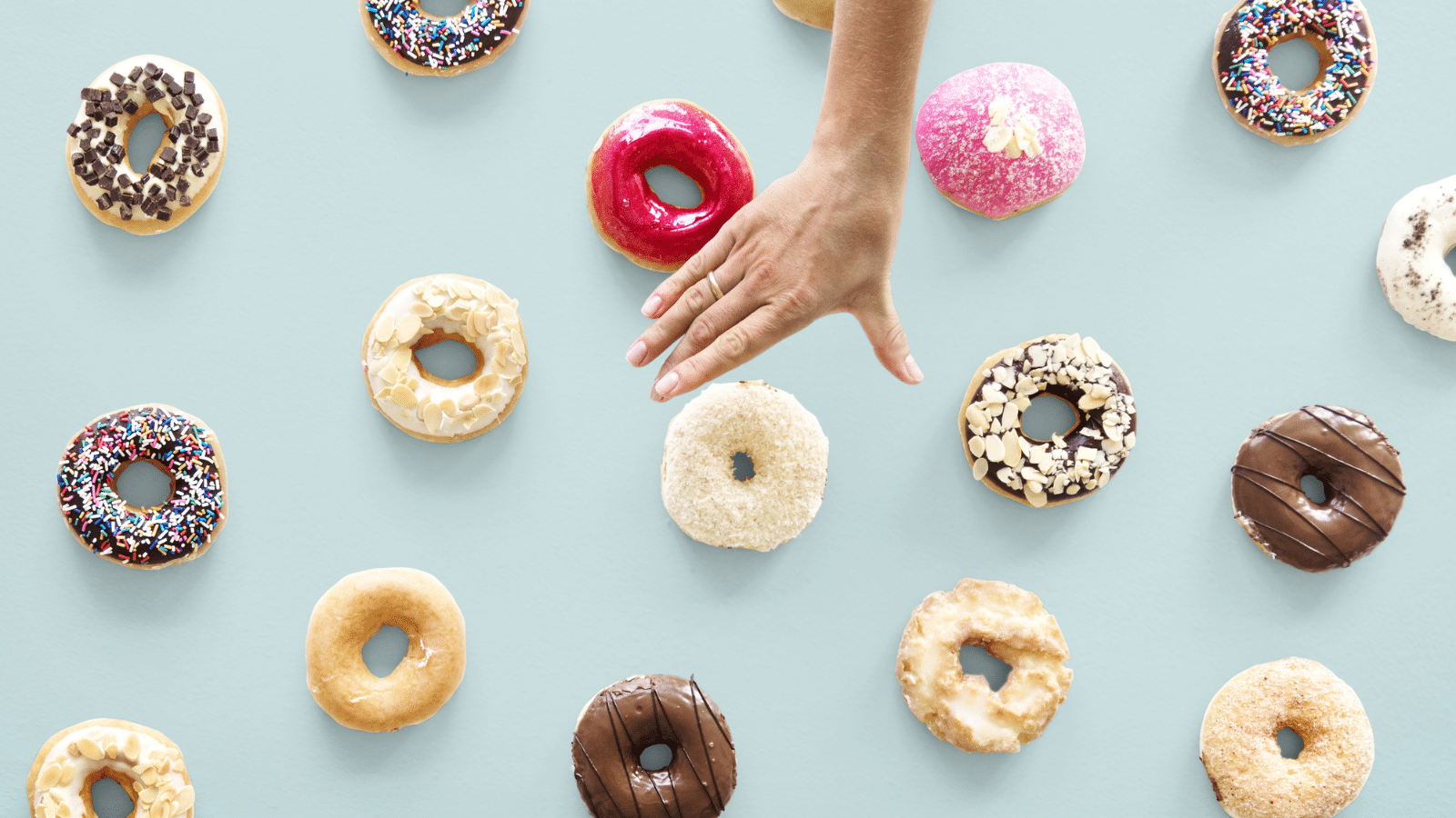 A hand reaching for donuts.