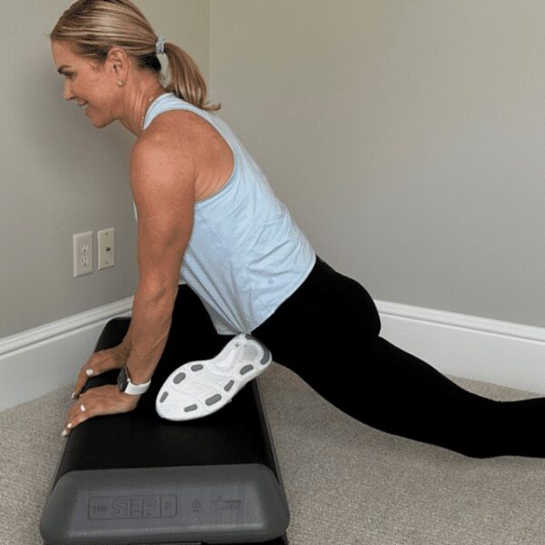 Chris Freytag performing the elevated pigeon pose on the step platform.