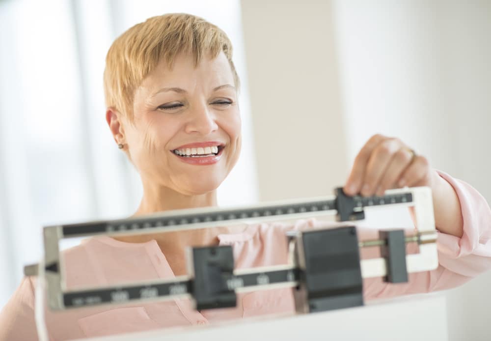 woman smiling at scale measurement