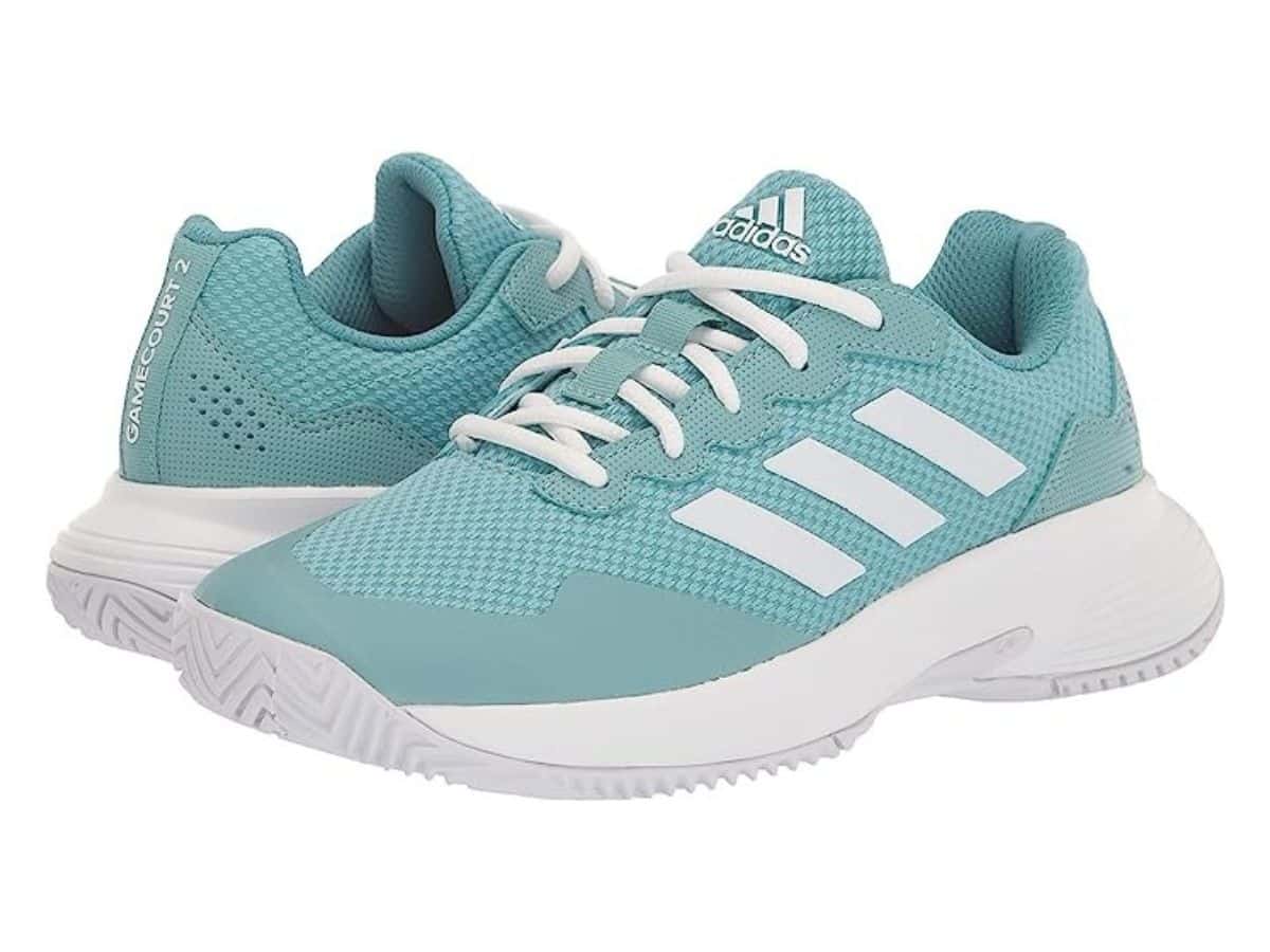 A pair of mint green Adidas tennis shoes with white strips and sole.
