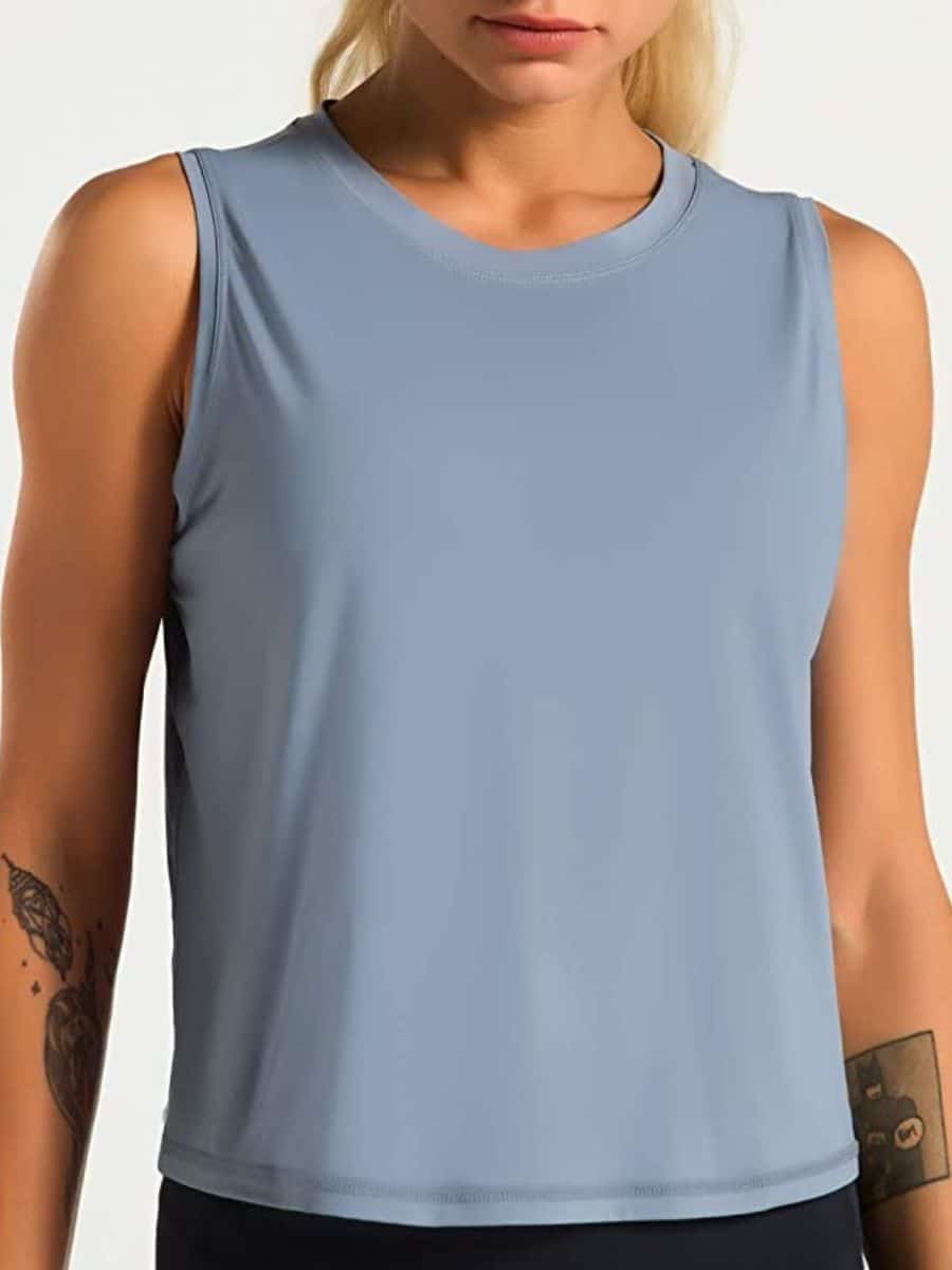 A person wearing a blue Dragon Fit sleeveless yoga top.