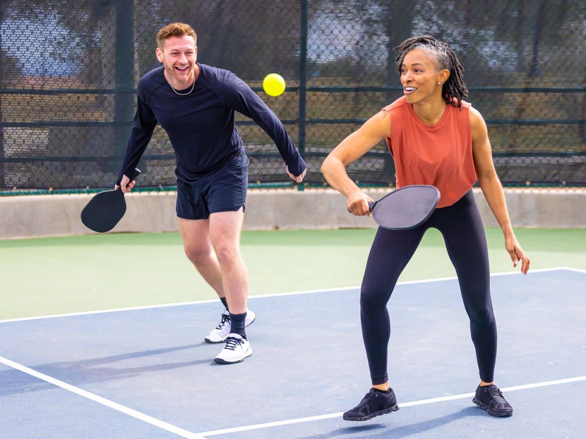 Two radical   playing a crippled  of pickleball connected  a tennis court. 
