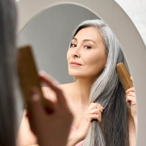 woman combing hair in mirror