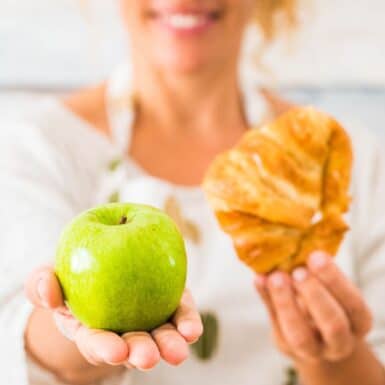woman learning how to quit sugar choosing apple over croissant