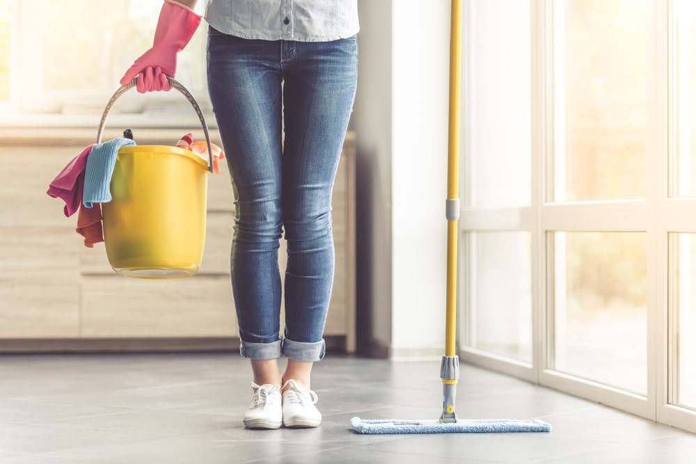 Woman successful  gloves holding a mop bucket successful  the kitchen.