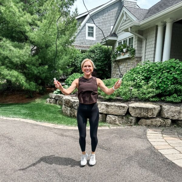 woman showing weight loss motivation with jump rope on driveway