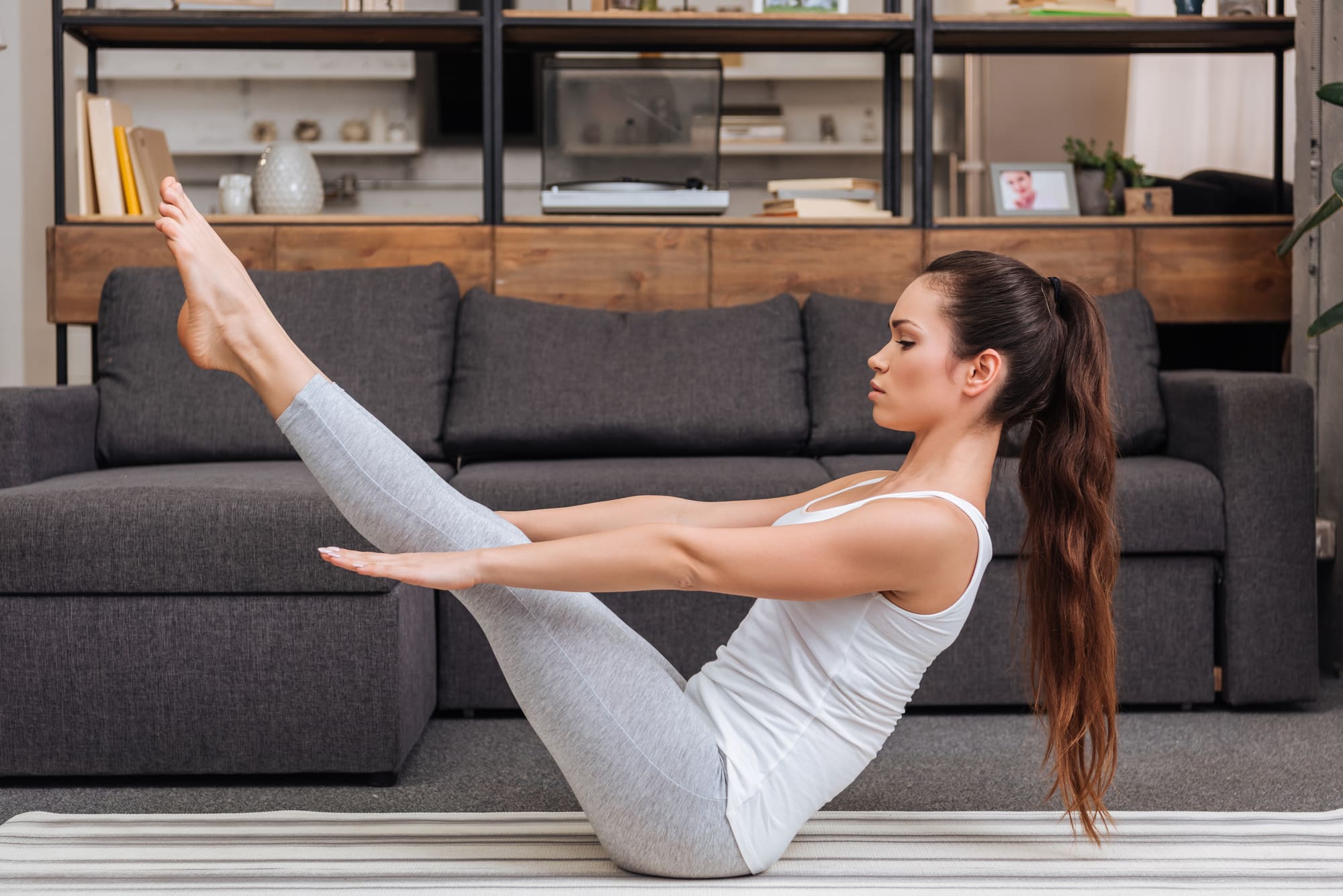 A woman performing a yoga boat pose.