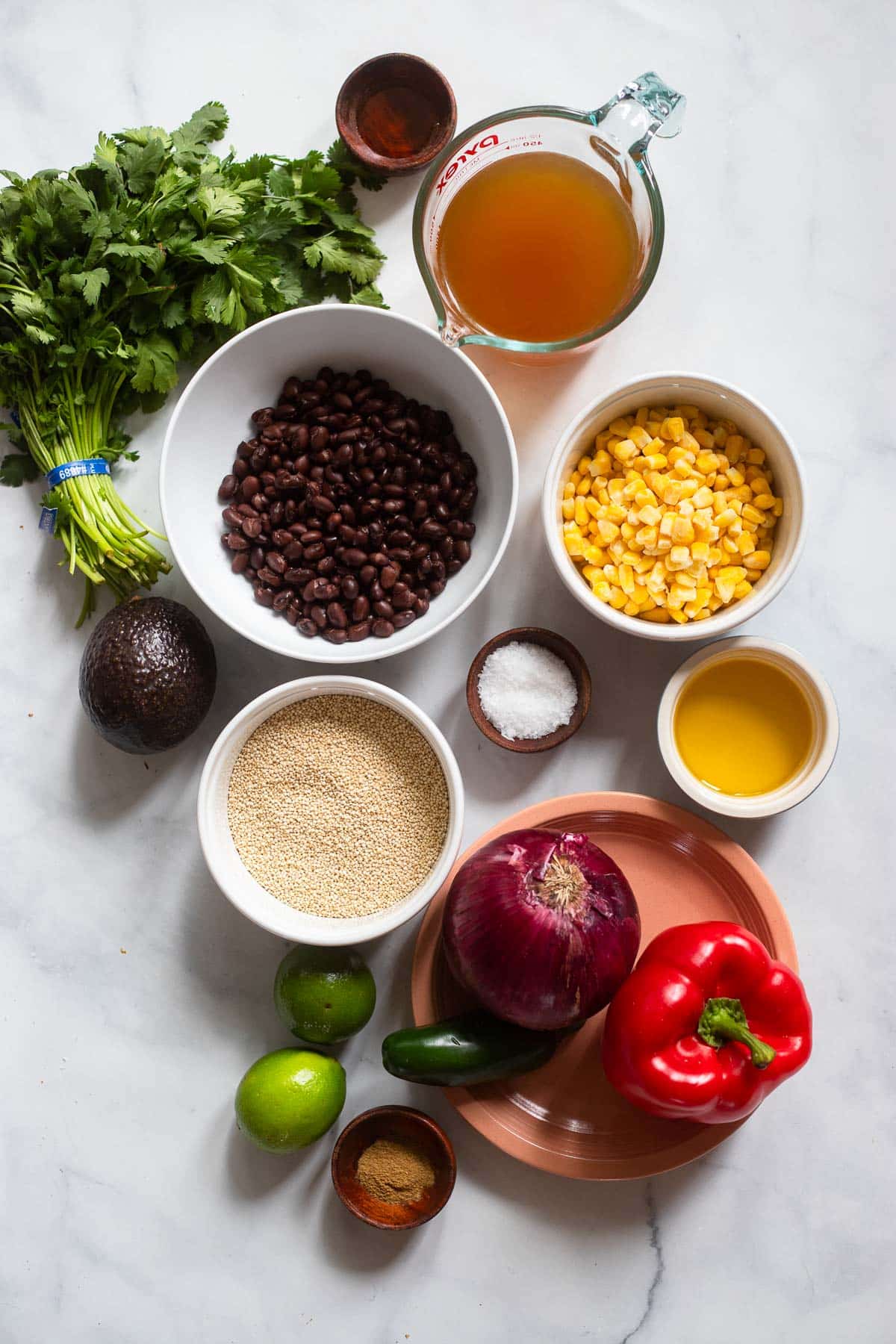 overhead show of raw ingredients for southwest quinoa salad on white countertop