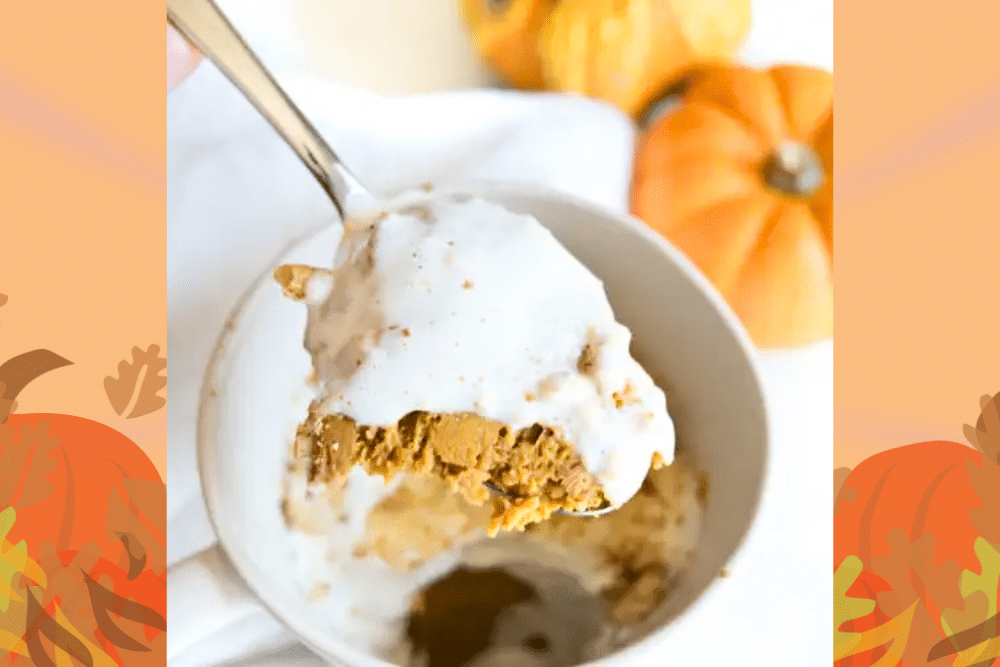 Close-up of a spoonful of pumpkin pie from a mug.