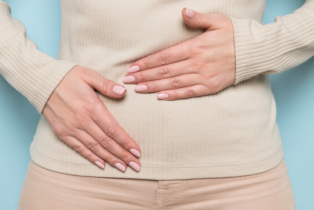 Close-up of woman holding her stomach.