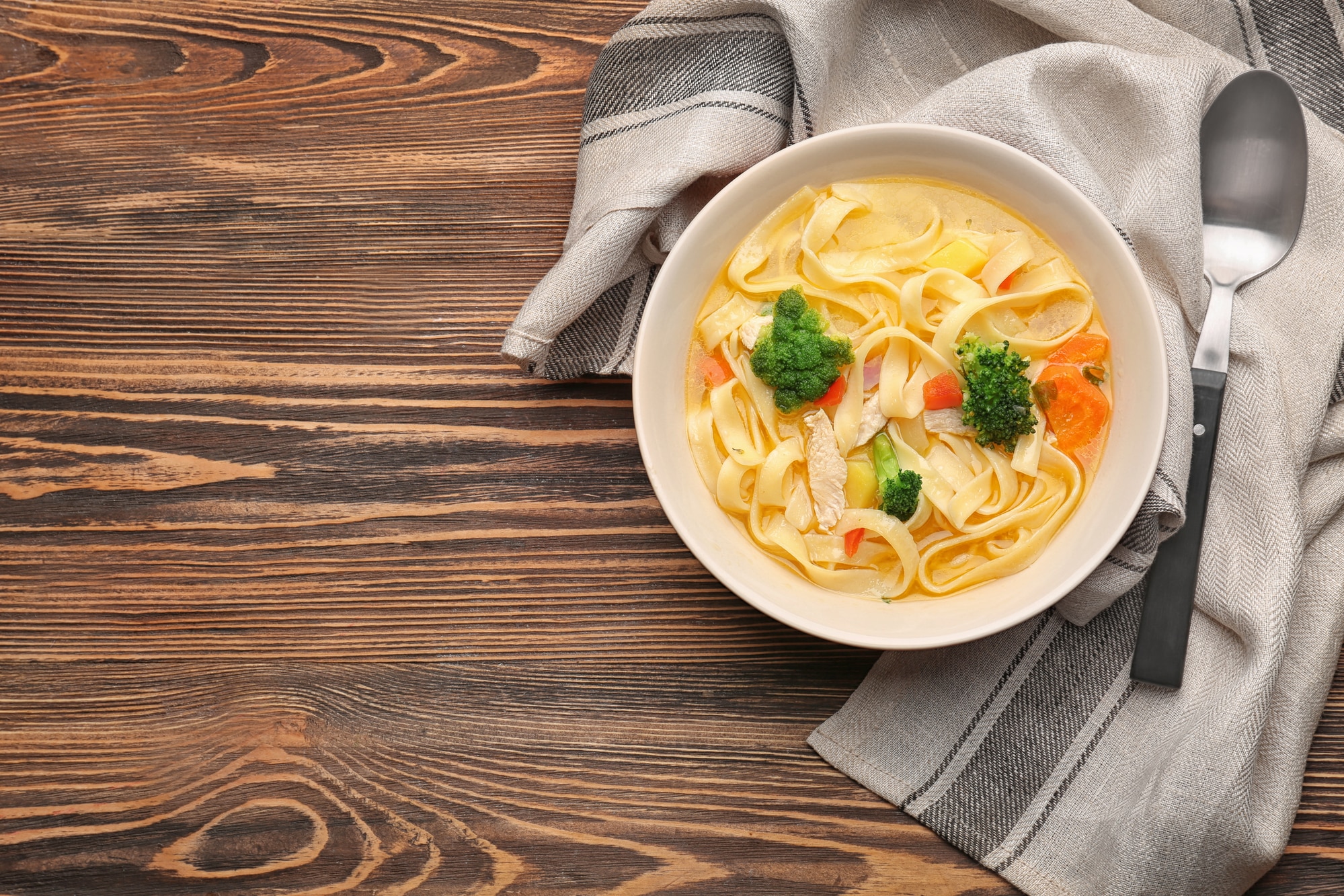 Chicken noodle soup in bowl on wooden table