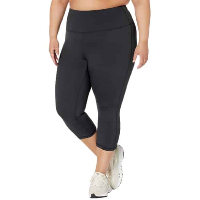 bottom half of woman wearing black cropped leggings and white tennis shoes