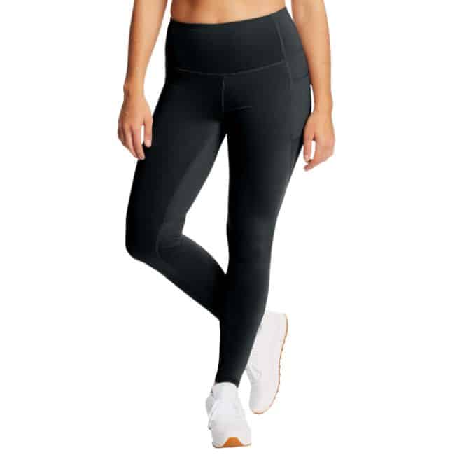 bottom half of woman wearing black leggings with pockets wearing white tennis shoes