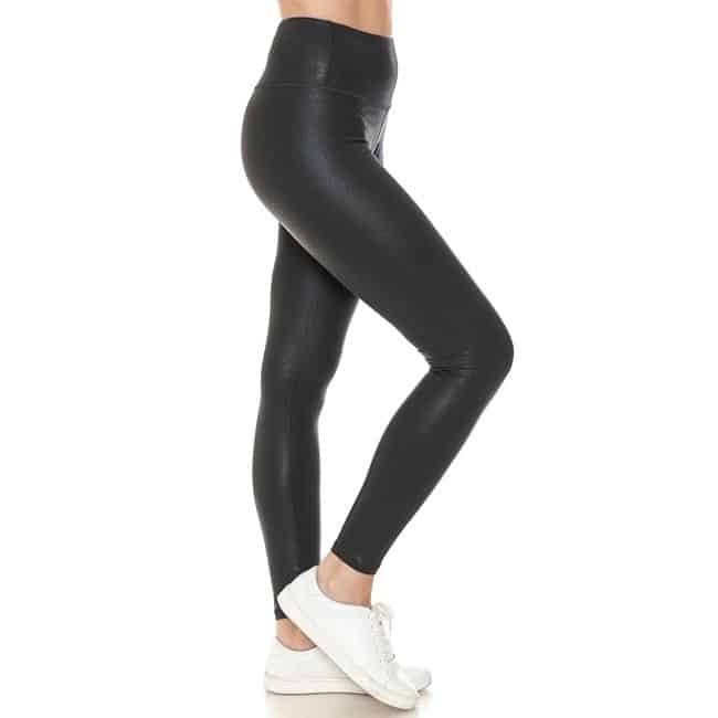 bottom half of woman wearing black faux leather leggings and white tennis shoes