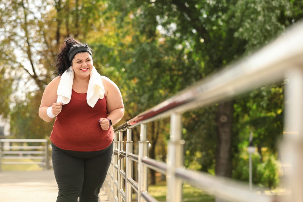Overweight woman running outdoors.