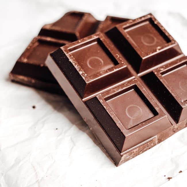dark chocolate squares laying on white packaging