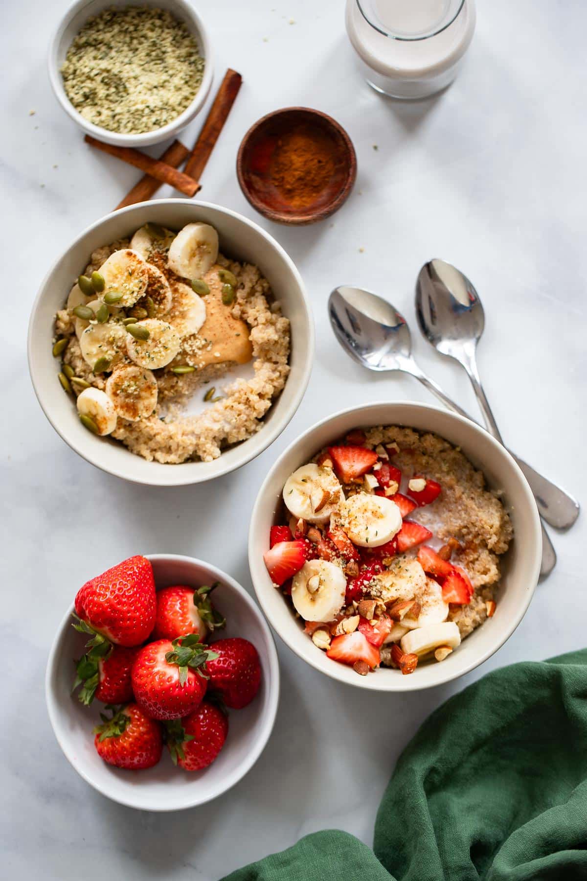 overhead view of quinoa breakfast bowl servings with fresh fruit toppings