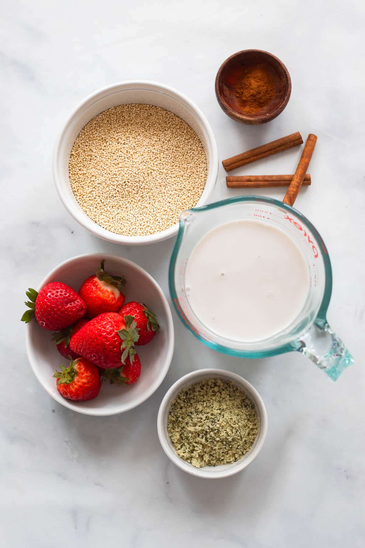 overhead view of raw ingredients to make quinoa breakfast bowl on white counter