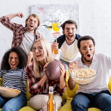 group of friends watching football game with healthy appetizers