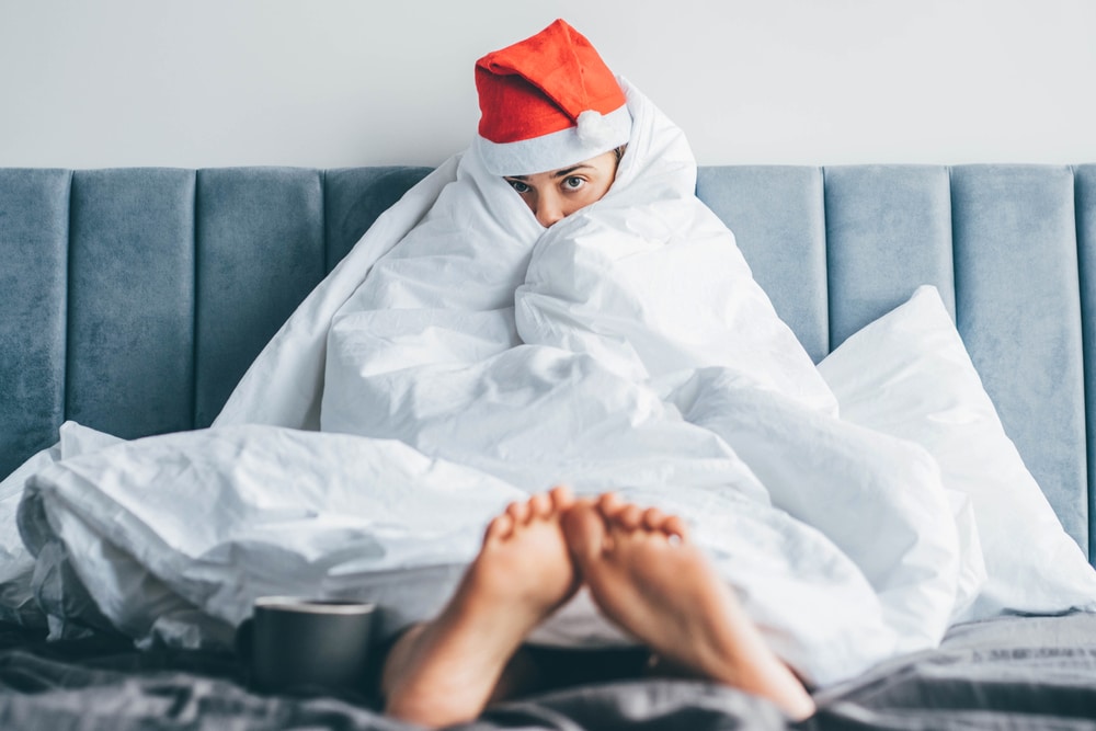 woman with holiday hangover on hovel with santa hat