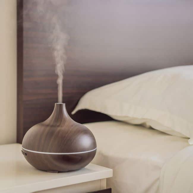wood diffuser next to bed