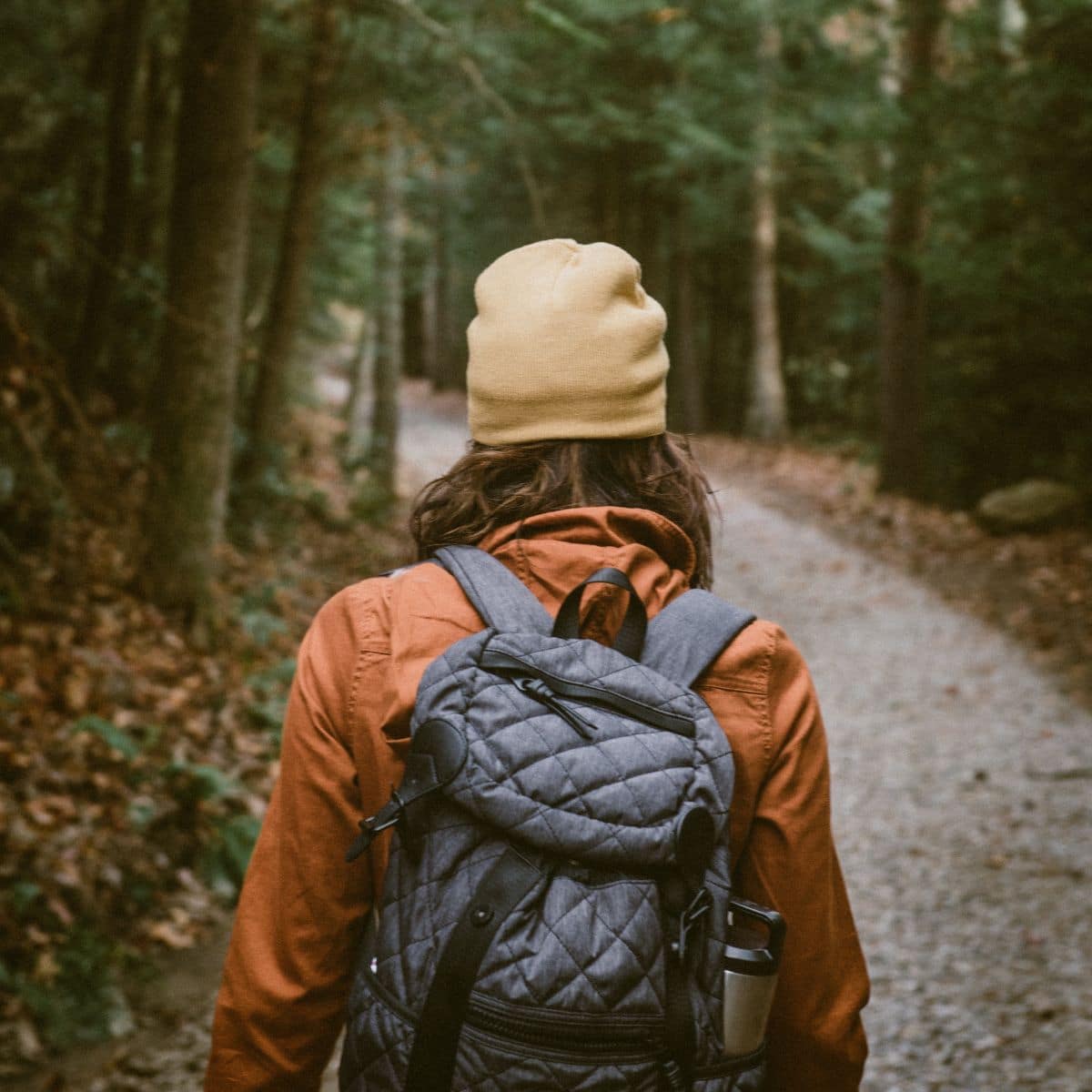 woman with weighted backpack rucking in woods